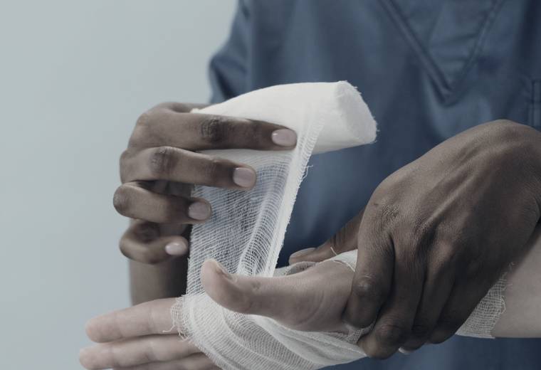 A clinician wrapping an injured hand